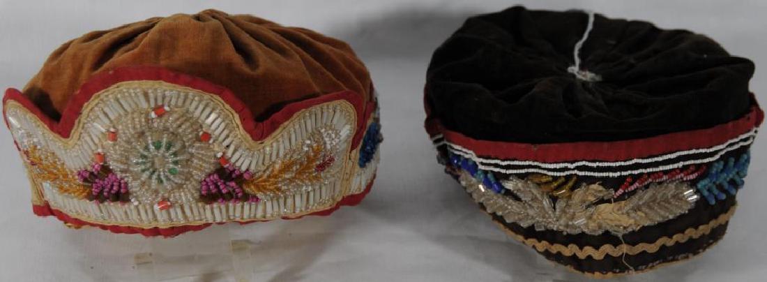2 BEADED IROQUOIS HATS ROUND STYLE BEADED HAT ON: RUST VELVET, RED MATERIAL BORDER WITH RUST MATERIAL INTERIOR. IROQUOIS, WOODLANDS. ROUND, PUMPKIN STYLE BEADED HAT ON BLACK VELVET, BROW CAMBRIC INTERIOR WITH RED MATERIAL TRIM, NO TOP BEADWORK. IROQU