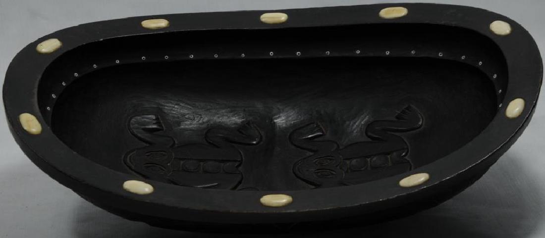 EARLY TLINGIT GREASE BOWL WITH STYLIZED FACES: CARVED ON BOTH END AND SIDES, THERE ARE 10 BONE/IVORY INSERTS ON THE RIM. THIS HAS BEEN LOOKED AT BY A PROFESSIONAL APPRAISER AND BEEN AUTHENTICATED TO BE AN EARLY HAIDA BOWL, BUT THE FROGS HAVE BEEN 
