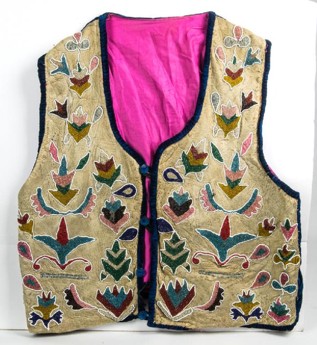 POTOWATOMI BEADED MAN'S VEST: MULTI-COLOR BEADWORK ON DEER SKIN, OUTLINED IN WHITE, REDS, BLUES, COBALT, PINKS AND AQUA, PINK SILK LINED INTERIOR, NAVY BLUE VELVET TRIMMED, BLUE BUTTONS, 1ST HALF OF 20TH C., 23" L, 21" W.