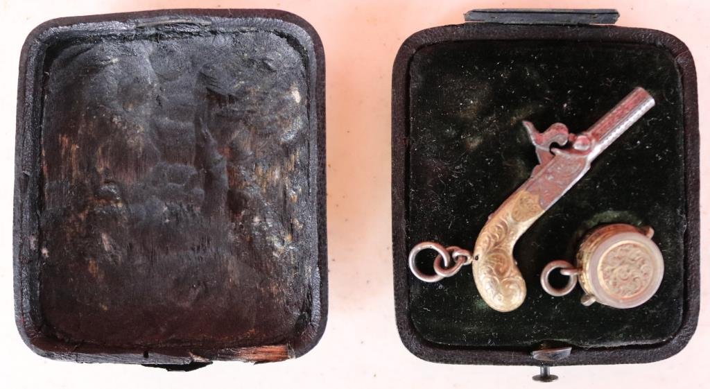 UNUSUAL 19TH C. MINIATURE PERCUSSION PISTOL: IN FITTED CASE WITH CAP BOX, ENGRAVED BARREL AND GRIP, DROP DOWN TRIGGER, 1 3/4" L, HINGE ON CASE BROKEN