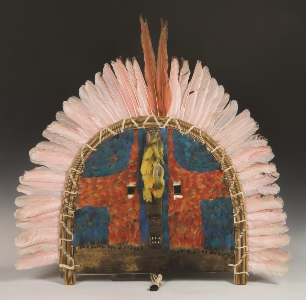 SPECTACULAR CONTEMPORARY BRAZILIAN, CLASSIC FLAT: WOOD MASK, DECORATED WITH FEATHERS, MOTHER-OF-PEARL, BENT REED BRAIDED WITH STRING, AND BONE TEETH, REMNANTS OF A "GREG MANNING GALLERY" TAG.