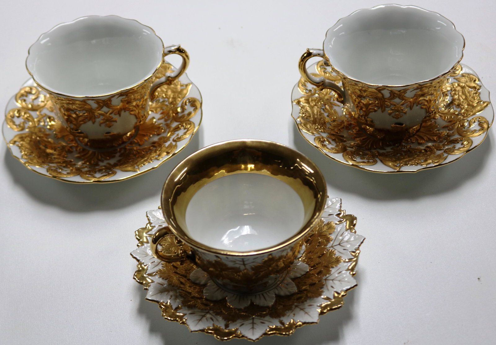 LOT OF 3 MEISSEN EMBOSSED & GILT CUPS & SAUCERS,: 2 MATCHING 1 WITH LEAF FORM