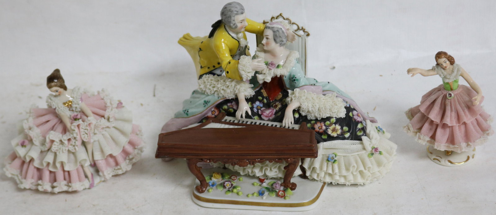 LOT OF 3 DRESDEN FIGURINES WITH LACE WORK: DRESSES, OVERALL VERY GOOD CONDITION, WOMAN WITH PIANO 6" H, 8 1/2" W, 6 1/2" DEEP, 2 DANCERS APPROX. 4" H