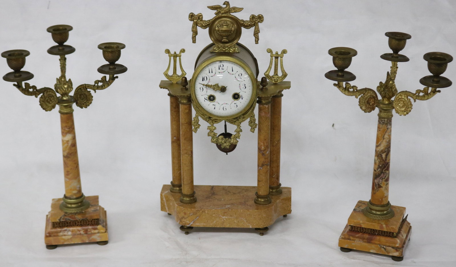 3 PC BRASS & MARBLE CLOCK SET WITH GILT BRONZE: TRIM, CLASSICAL STYLE, WITH COLUMNS, UNKNOWN WORKING CONDITION, SPRINGS OK, CLOCK 15" H, 8 3/4" W, 4" DEEP, CANDELABRAS 13" H, 7" W, ENAMELED FACE SHOWS HAIRLINES & REPAIRS, MOVEMENT IS JAPY FRERES, O