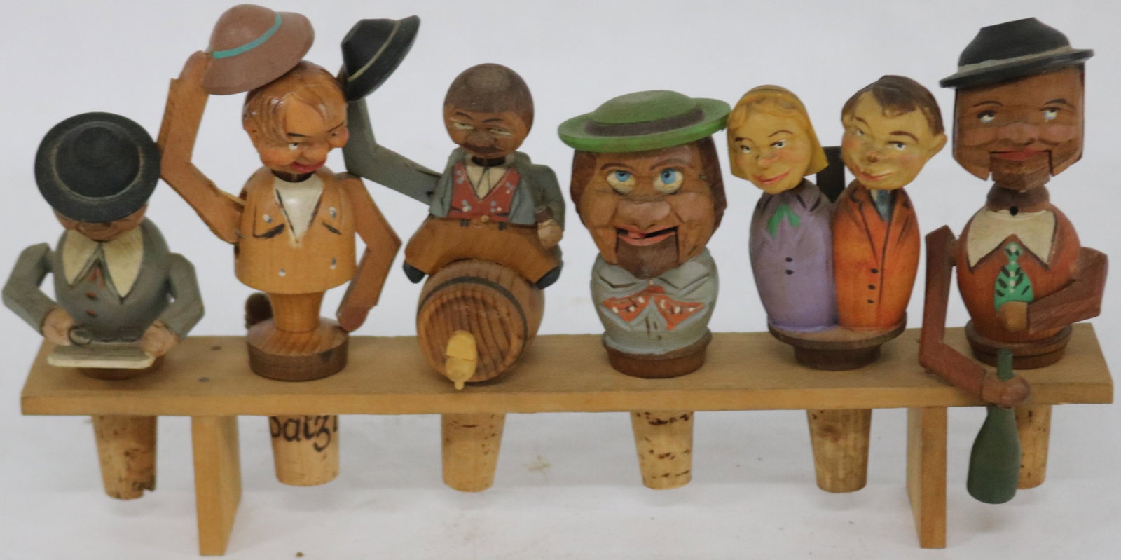 COLLECTION OF 6 CARVED AND PAINTED GERMAN: MECHANICAL BOTTLE CORKS, ON FITTED BENCH APPROX. 4 1/2" - 5 1/2" H, 1 1/2" - 2" W