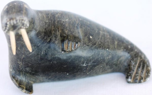 ESKIMO CARVED STONE WALRUS, WITH IVORY TUSKS SIGNE: ESKIMO CARVED STONE WALRUS, WITH IVORY TUSKS SIGNED OOLAXOOK, E4-275, 4" L