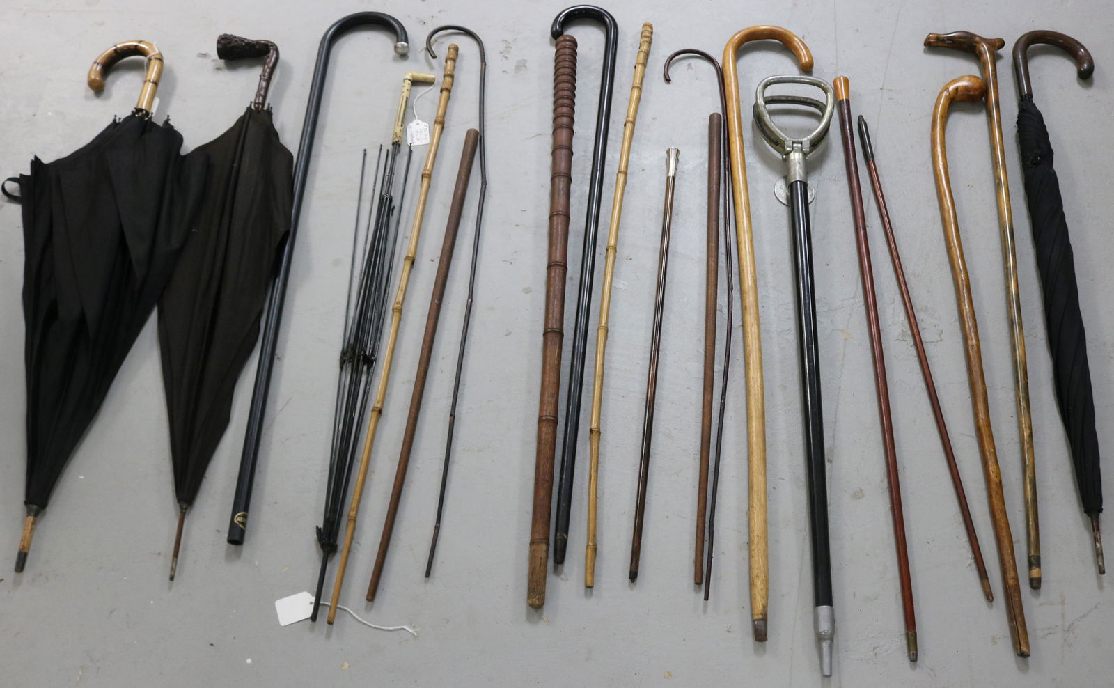 COLLECTION OF 20 CANES, UMBRELLAS AND WALKING: STICKS (WOOD, METAL, BAMBOO, ETC.) ONE WITH STERLING MILITARY TOP, ANOTHER WITH BONE & ABALONE INLAY