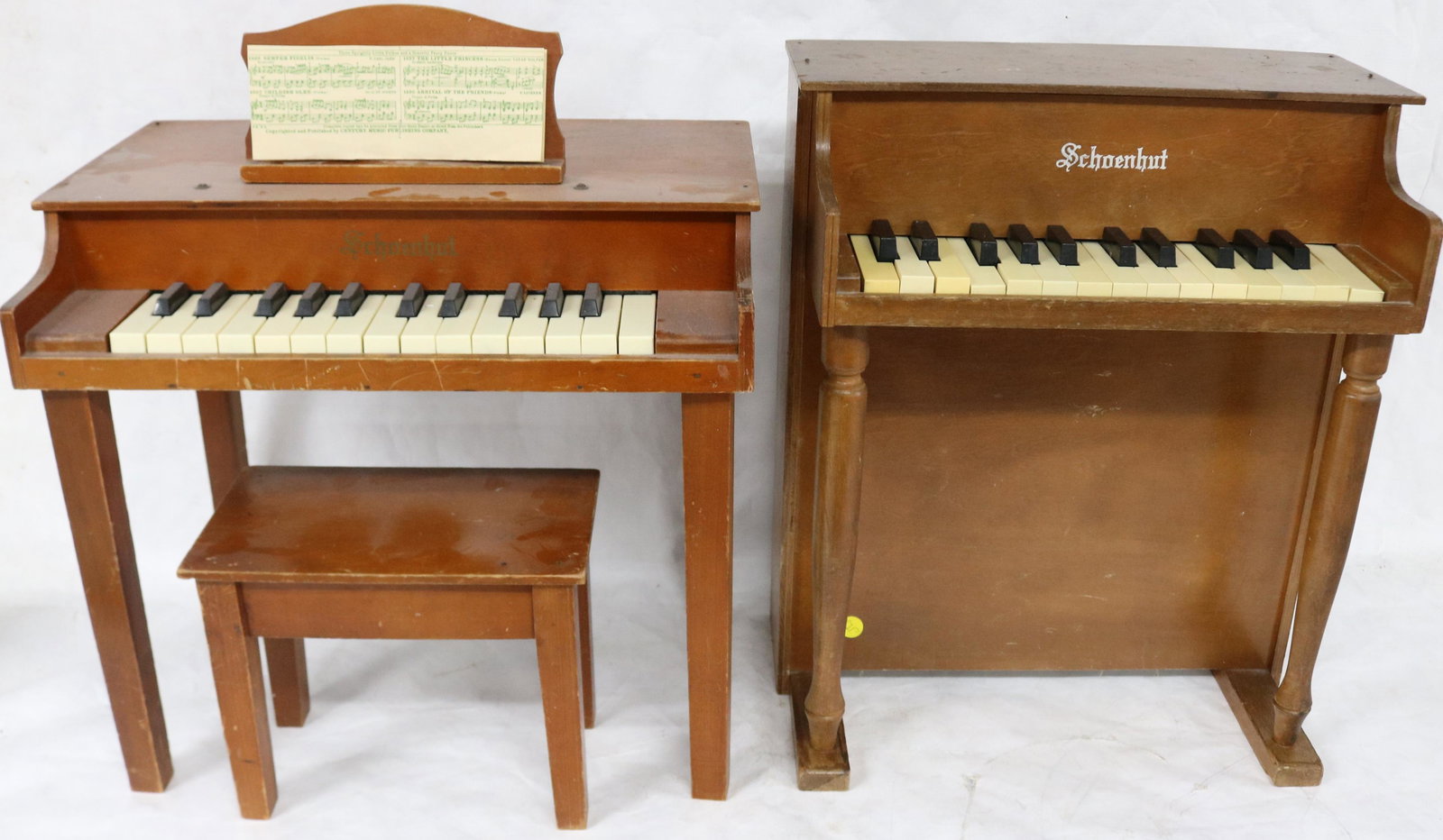 2 SCHOENHUT TOY PIANOS, ONE WITH STOOL & MUSIC: RACK, BOTH IN WORKING CONDITION, 20" & 21 1/2" H, 15 3/4" & 18 1/2" W, 10" - 13" DEEP, STOOL 8 1/2" H, 10 1/2" W, 6 1/2" DEEP
