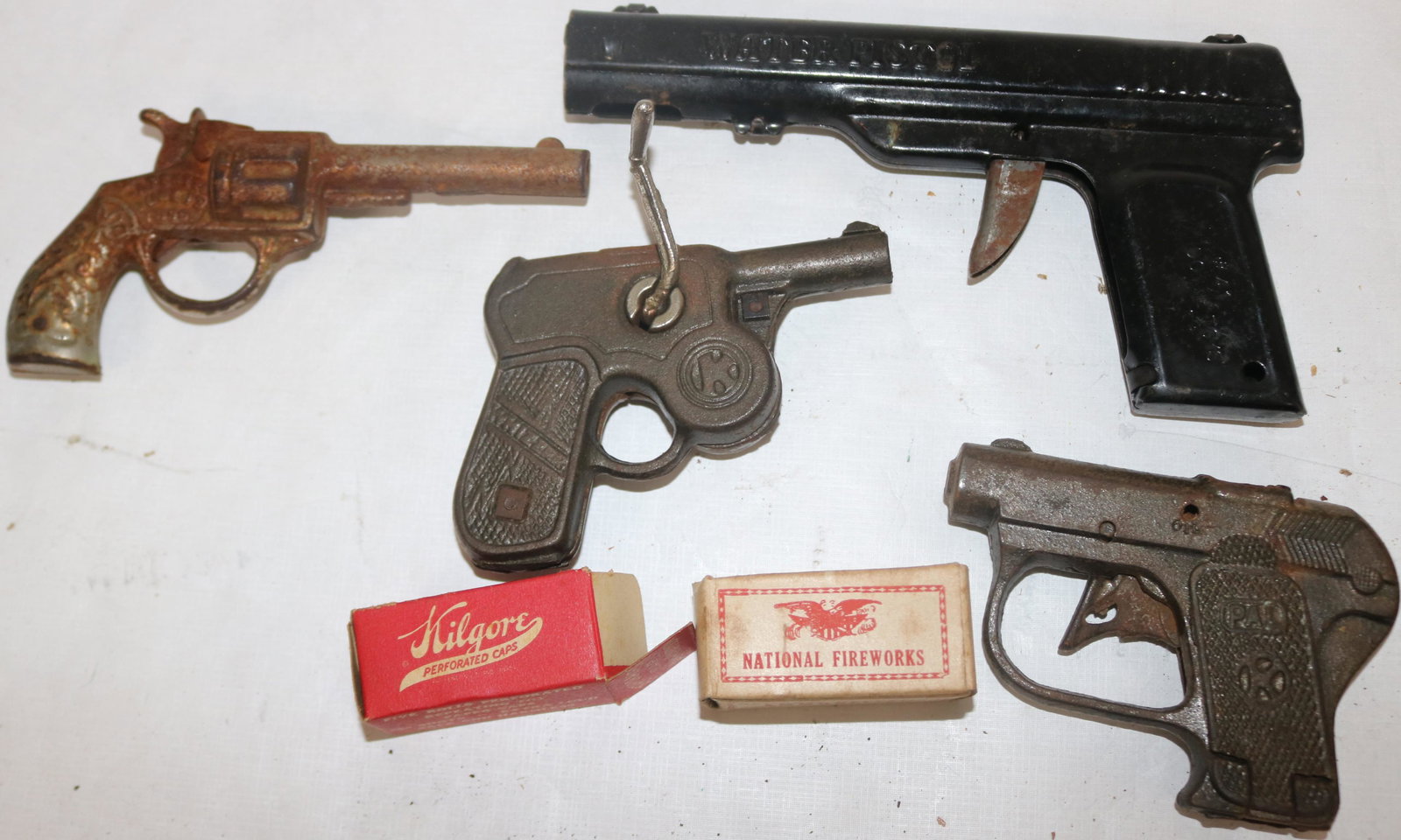 LOT OF 4 TOY GUNS TO INCLUDE 3 CAP AND WATER GUN,: ONE SIGNED WIZARD WITH RAPID FIRE MECHANISM TOGETHER WITH 2 BOXES OF CAPS, APPROX. 200 ROUNDS OF CAPS, IN ORIGINAL BARN FOUND CONDITION