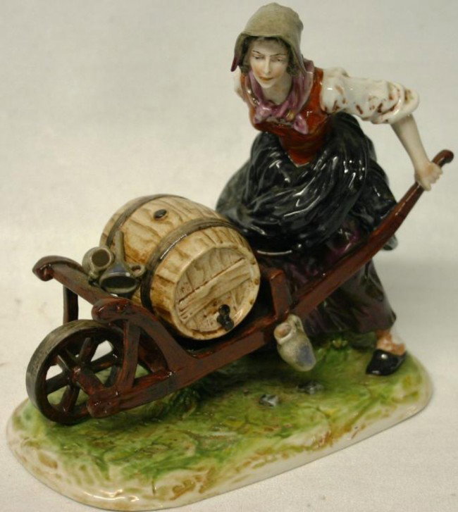 CAPODIMONTE PORCELAIN FIGURINE OF WOMAN: WITH WINE BARREL IN A WHEEL BARREL, 7" H, 7" L