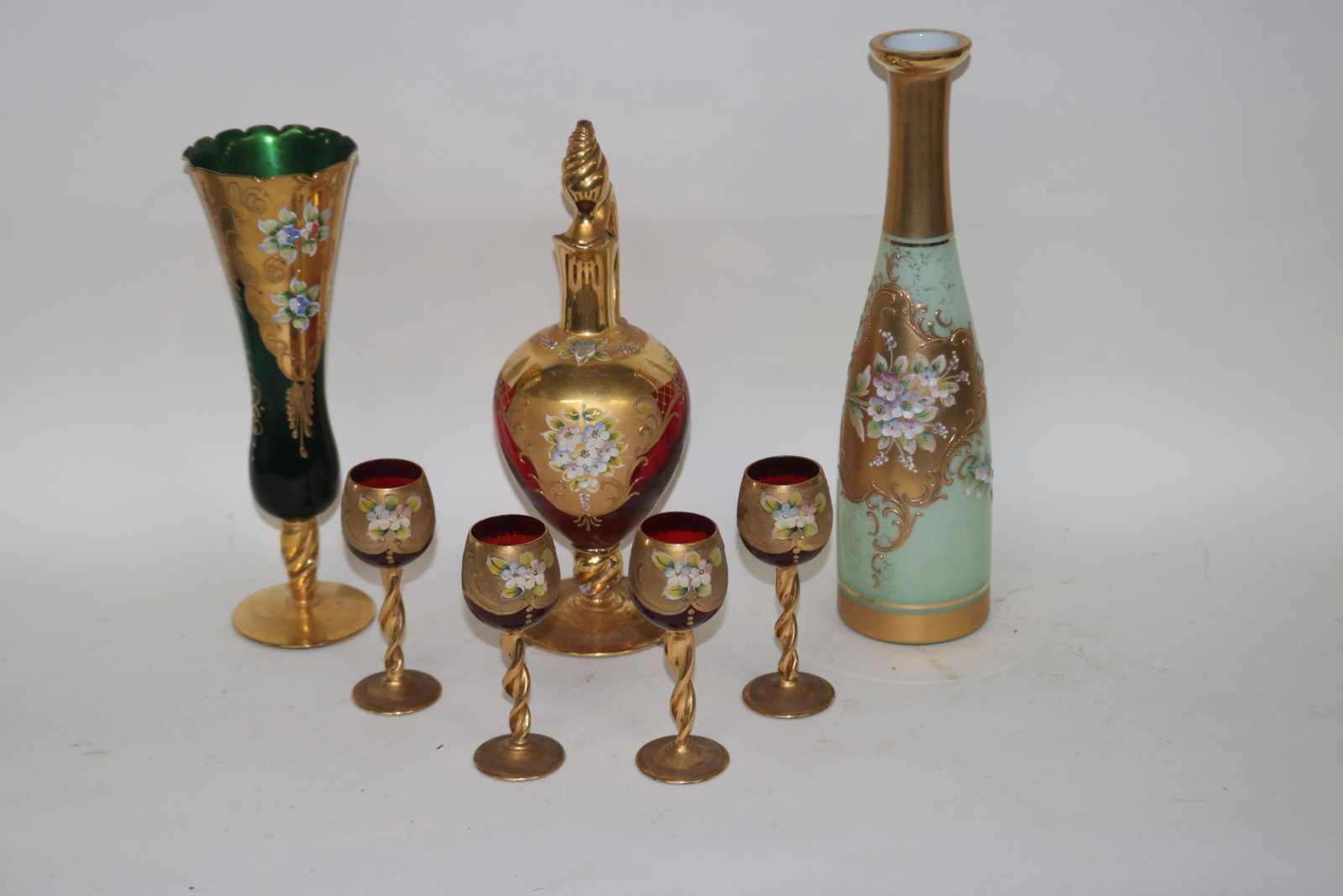 LOT OF 7 PIECES OF GILT AND ENAMELED GLASS: INCLUDING STOPPERED JUG WITH FOUR CORDIALS, 11" AND 5" H. A 10 1/4" BOTTLE AND 12 1/4" BOTTLE.