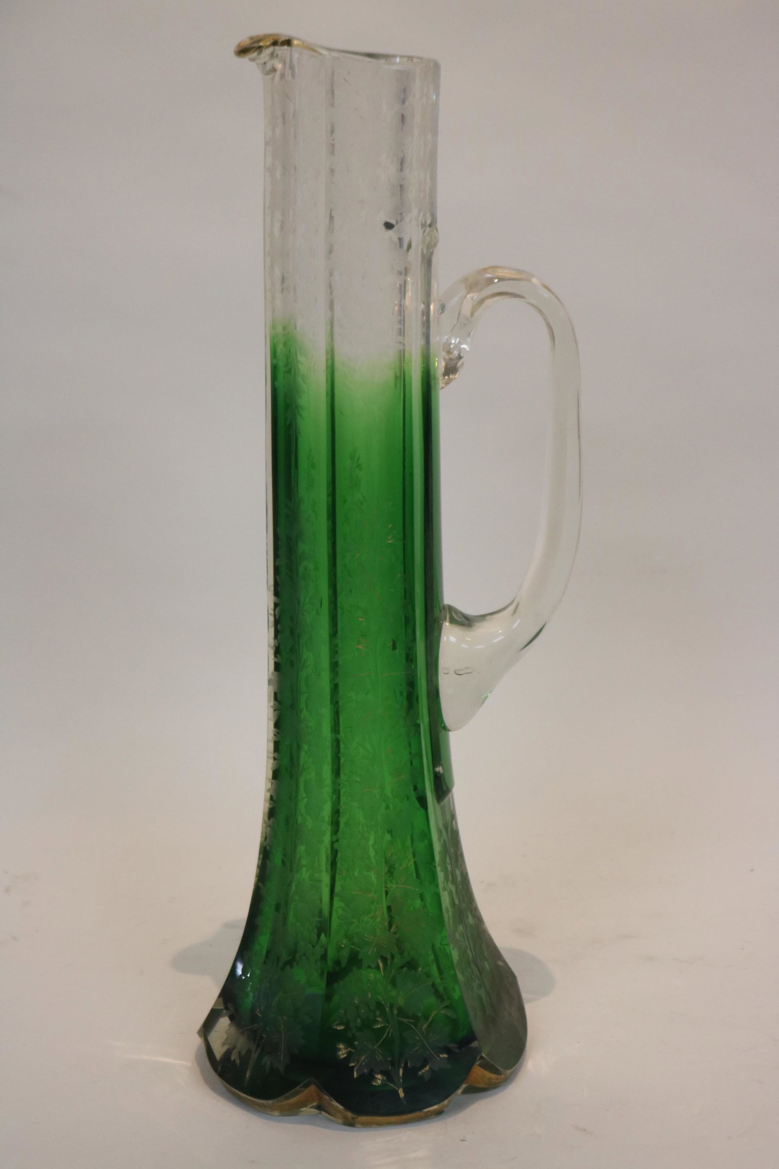 TALL CUT AND ETCHED HANDLED EWER: WITH GOLD TRIM (SOME LOSS), CLEAR SHADED TO GREEN, 14" H. 4 1/2" DIA. AT BASE. POLISHED PONTIL AND BASE.