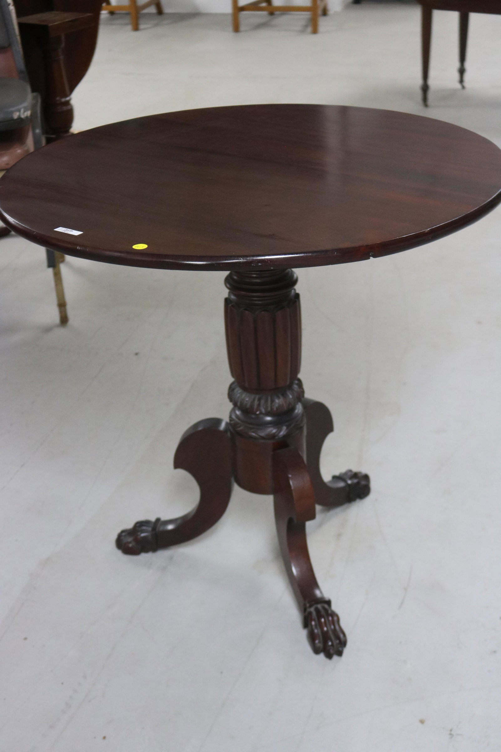 MAHOGANY TILT TOP TABLE: WITH CARVED AND FLUTED SHAFT AND CARVED CLAW FEET, 29 1/2" H, 32" DIA.