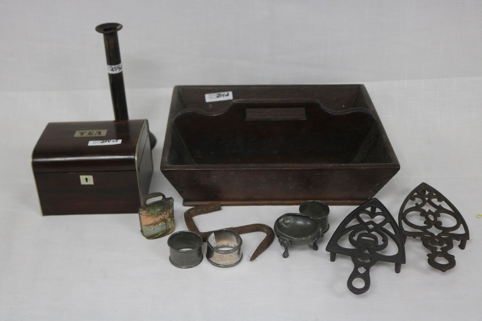 LOT TO INCLUDE: MAHOGANY TEA CADDY, MISCELLANEOUS FOREIGN COINS, SILVER PLATE NAPKIN RINGS, PEWTER SALTS, TWO TRIVETS, HOG SCRAPER CANDLE STICK, CUTLERY BOX, ETC. 1" TO 8 1/4" H,