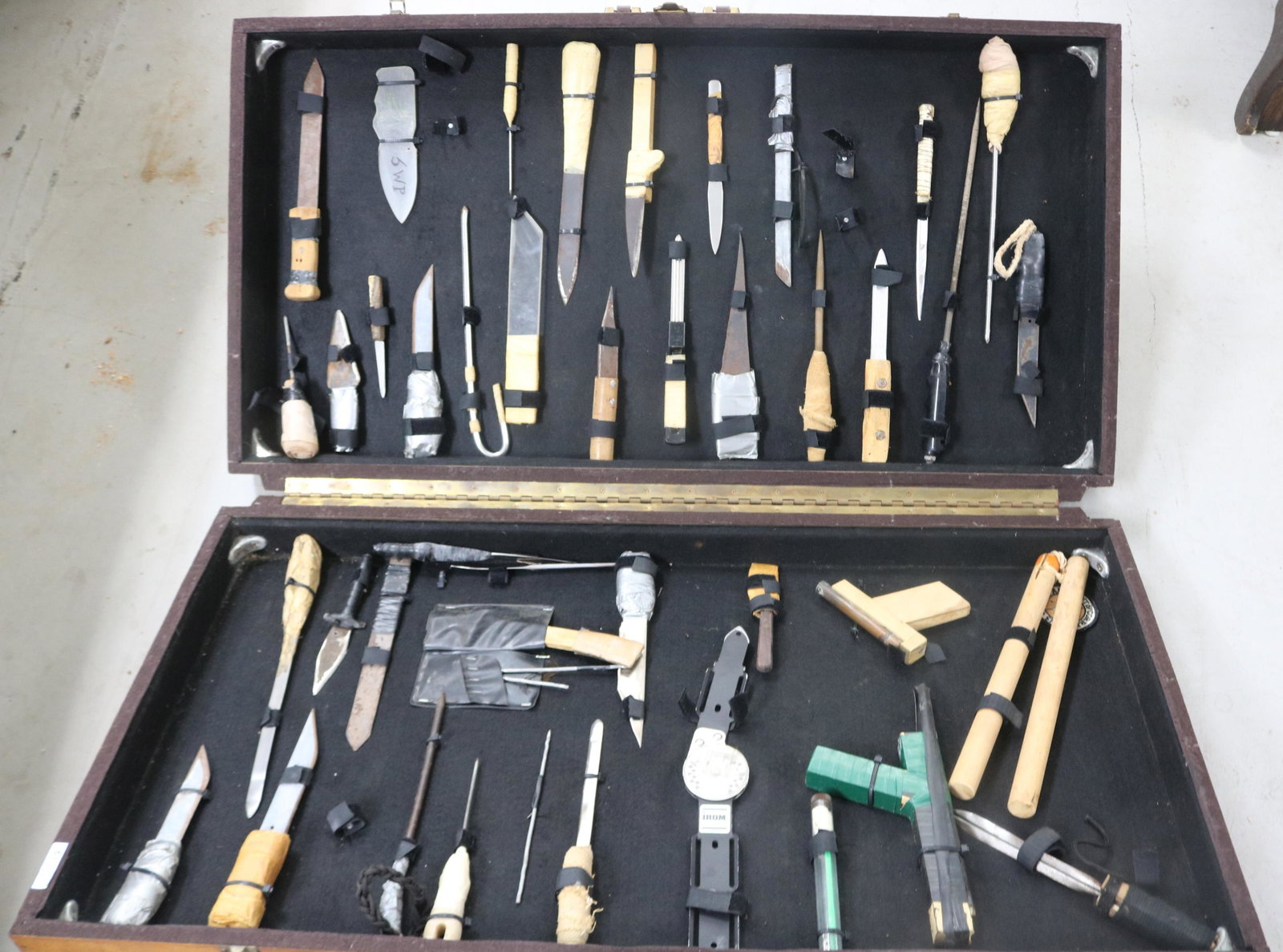 FLORIDA DEPARTMENT OF CORRECTIONS TEACHING: DISPLAY, PLYWOOD CASE WITH DISPLAYS OF SHIVS, & ZIP GUNS CONFISCATED FROM PRISONERS INCARCERATED AT THE COLEMAN FACILITY, CIRCA 1960s, APPROX. 40 WEAPONS OF VARIOUS DESIGN, CASE 22 1/2" H, 41 3/4" W, 