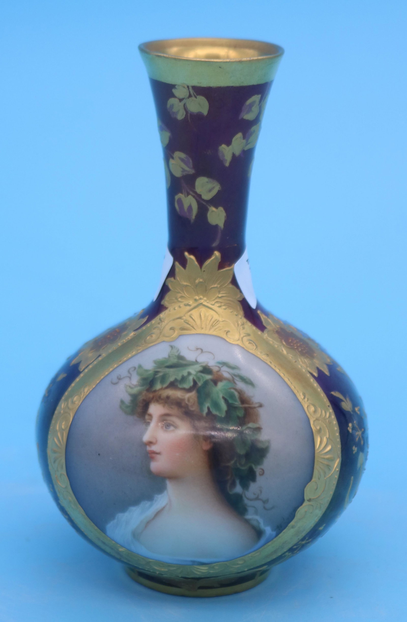 19TH C. PORCELAIN PORTRAIT VASE, SIGNED WAGNER,: AMETHYST GROUND WITH GILT ENAMELED DECORATION, PORTRAIT OF ARIADNE, BLUE BEEHIVE MARK, 5" H, 3" DIA.