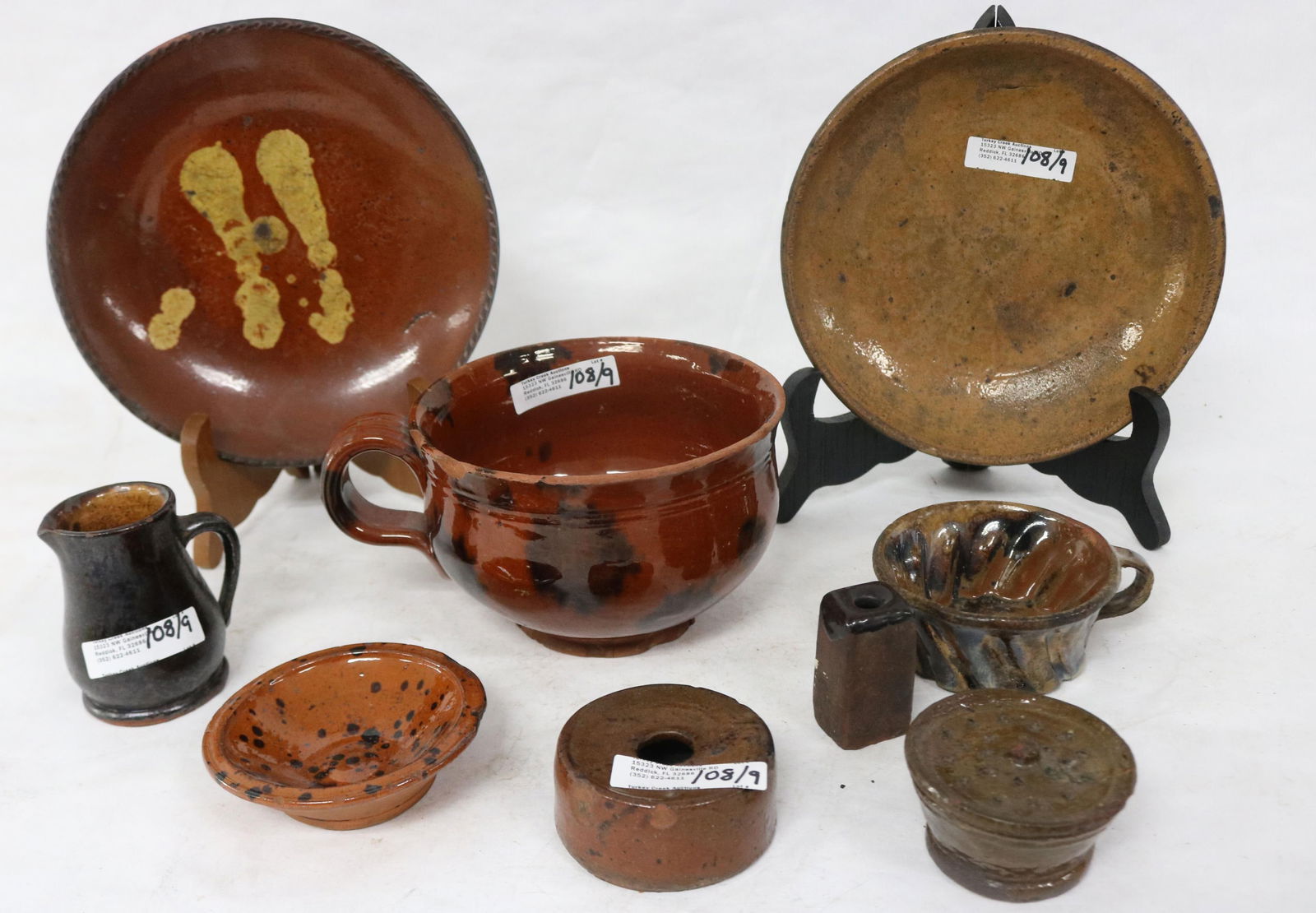 LOT OF NINE 19TH C. REDWARE ITEMS, SLIP GLAZED: PLATE 7 1/4" DIA., MUG 3 1/2" H, 5 1/2" DIA., CHIPS, PLATE 7" DIA., OTHER ITEMS CREAMER, INKWELL, SANDER, CUP, SMALL BOWL, ETC. 1" - 3" H, 1" - 3 1/2" W