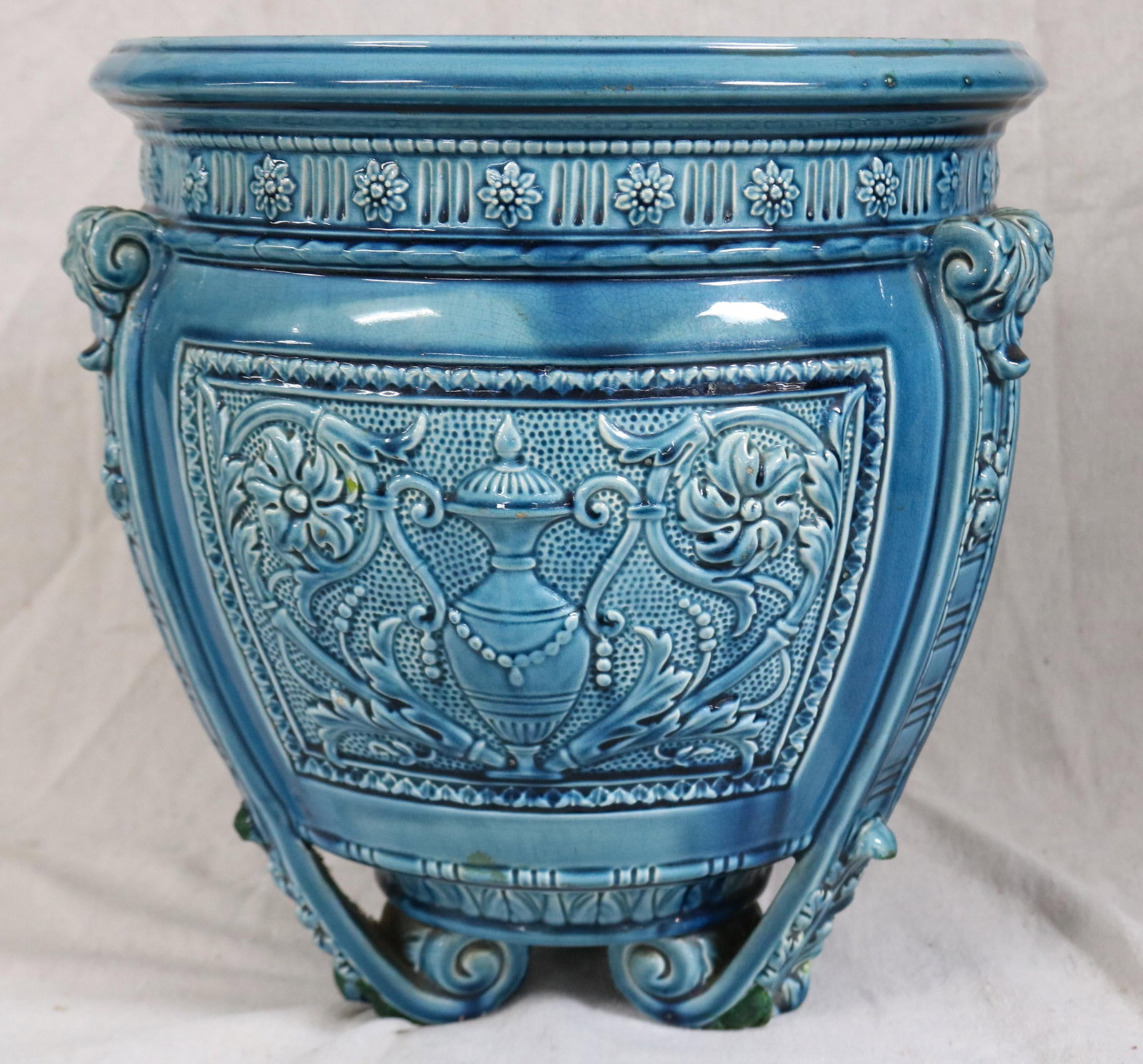 LATE 19TH C. FROSTED HIGH GLAZE JARDINIERE WITH: EMBOSSED URN DESIGN, BLUE HIGH GLAZE, SHOWS CHIP TO RIM, 13 1/4" H, 12 1/2" DIA.