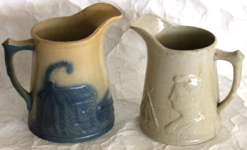 2 SALT GLAZE PITCHERS ONE WITH BLUE HIGHLIGHTS: BOTH WITH LOG CABIN, TEEPEE AND LINCOLN, 9" - 9 1/2" H
