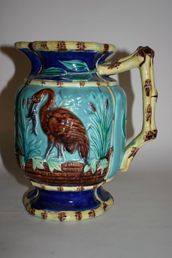 19th c. Majolica Pitcher: 19th century Majolica pitcher with bamboo handle, Heron and Fish design, slight glaze wear, 8 3/8" high