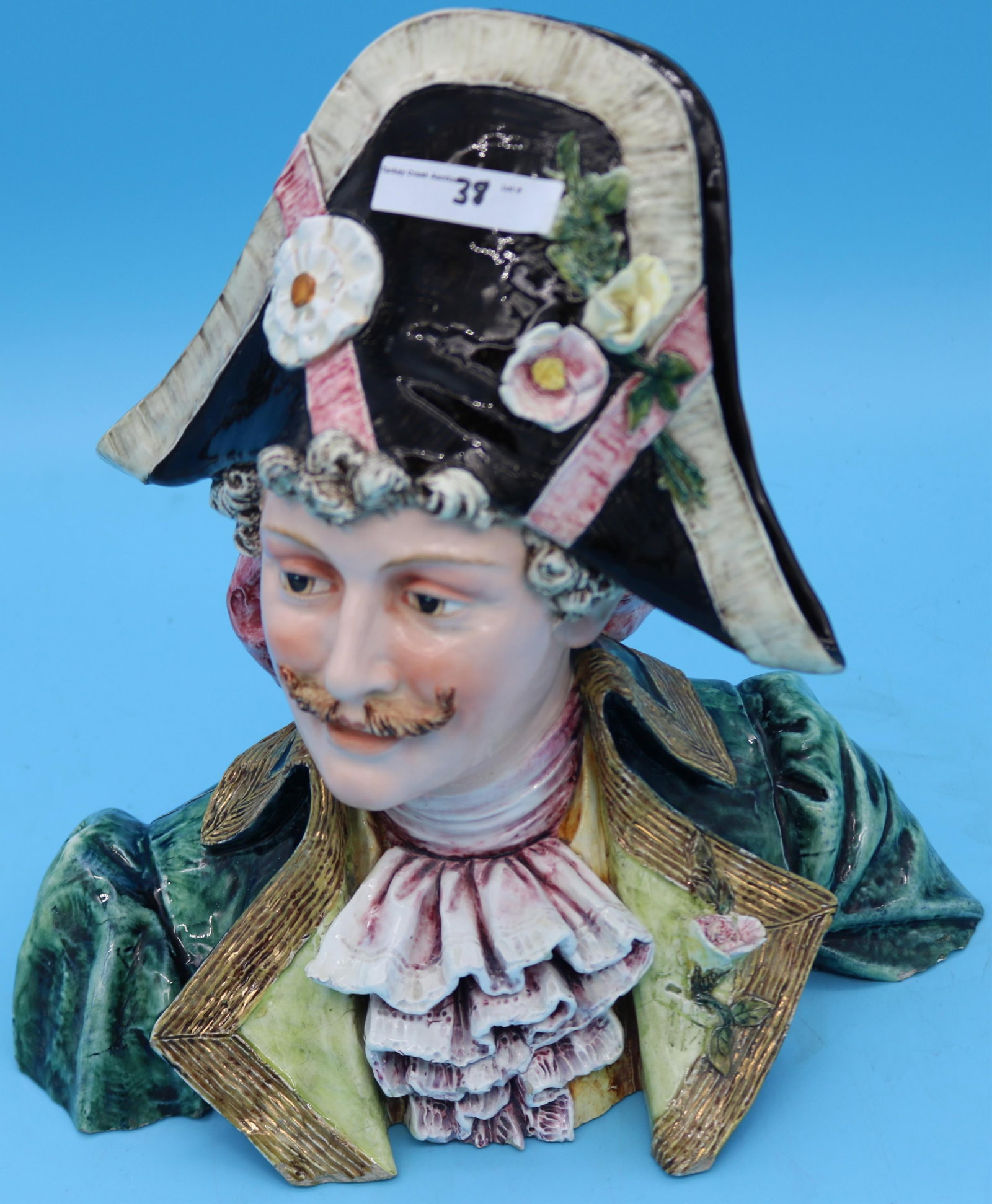19TH C. MAJOLICA BUST OF A MAN WITH FLORAL: DECORATED HAT, SLIGHT CHIPS TO BASE, 10 1/2" H, 10 1/2" L, 6" D