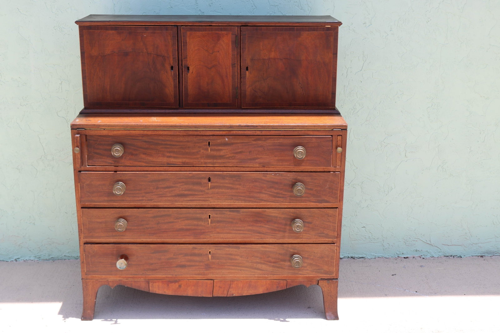 HEPPLEWHITE DESK, MAHOGANY, 3 DOOR TOP WITH BAND: INLAY, FITTED INTERIOR, FOLD DOWN WRITING SURFACE, 4 DRAWERS WITH DIAMOND INLAY ESCUTCHEONS, BRASS HARDWARE, ENDING WITH FRENCH FEET, MINOR LOSS TO VENEER, OLD REFINISHED CONDITION, AGE APPROPRIATE WE