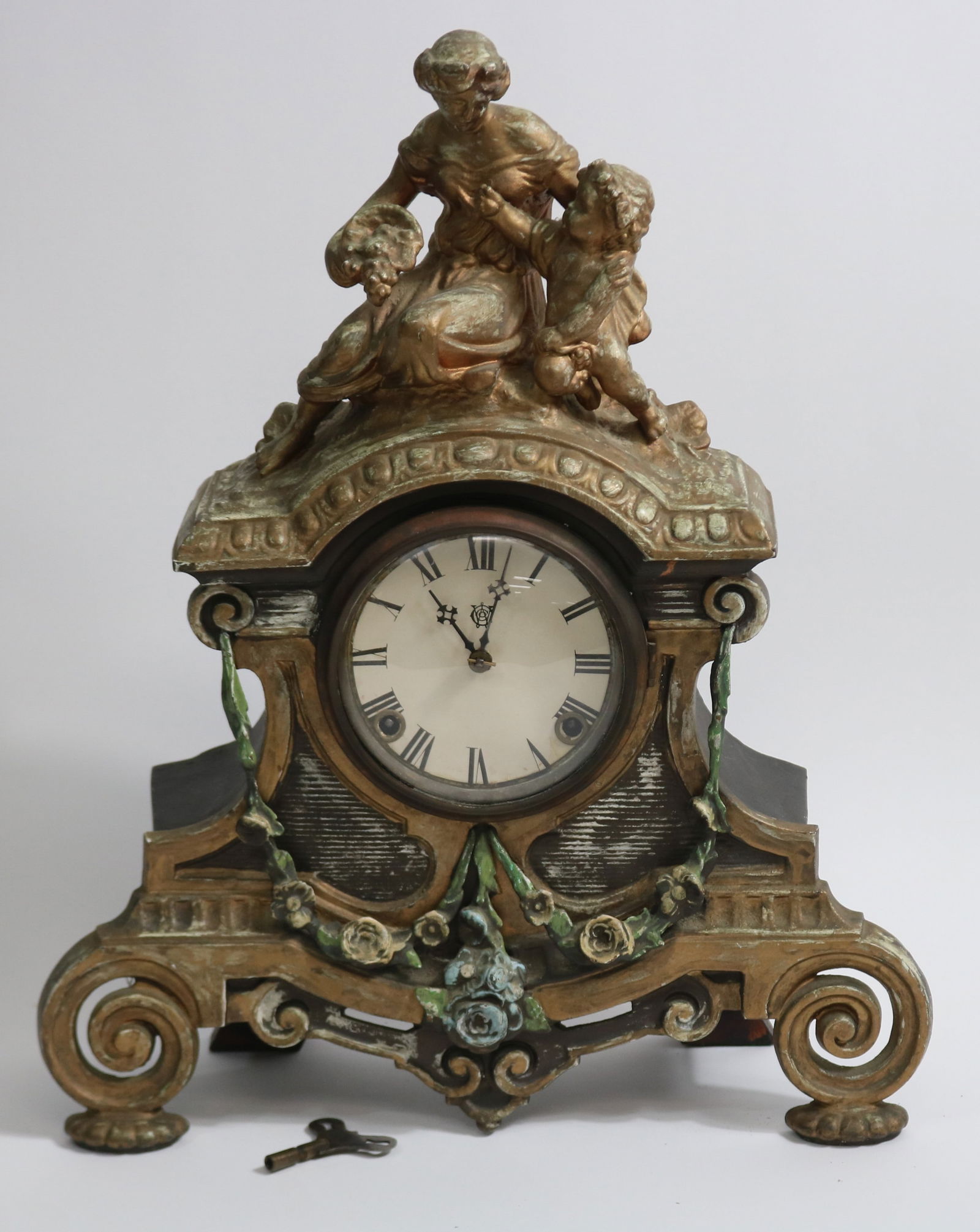 ORNATE CAST METAL FIGURAL MANTLE CLOCK, MOTHER &: CHILD TOP, FADED PAINTED FINISH, SPRINGS GOOD, KEY & PENDULUM, WOOD BACK, 19 1/2" H, 15 1/2" W, 5 1/2" D