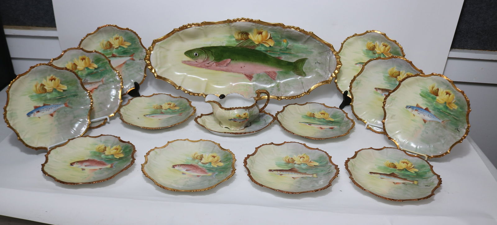 15 PCS. LIMOGES FISH SET, SIGNED BY ARTIST J.: MORRY?, PLATTER 24 1/2" X 10 1/2", (12) 9 1/2" PLATES, SAUCE BOAT 4 3/4" H, 7 1/2" W, UNDERLINER 9 1/2" X 6 1/2", NO CRACKS OR CHIPS, GOOD CONDITION