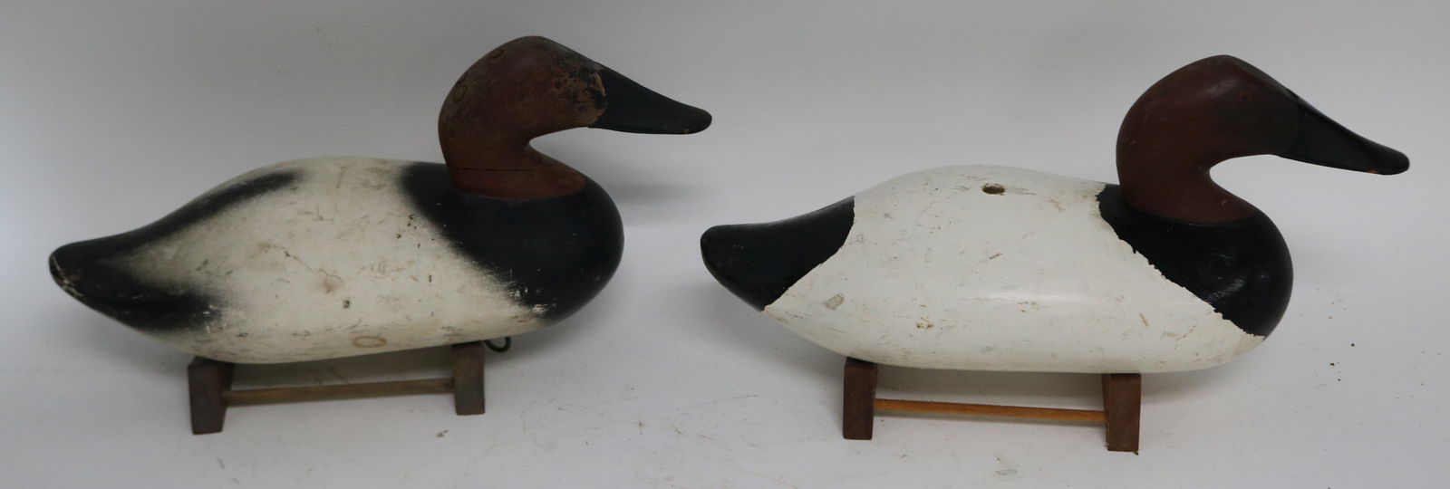 2 SIMILAR CARVED & PAINTED DECOYS, 1 WITH LATER: PAINTED SURFACE & HOLE, 7" H, 15 1/2" L, MID. 20TH C.