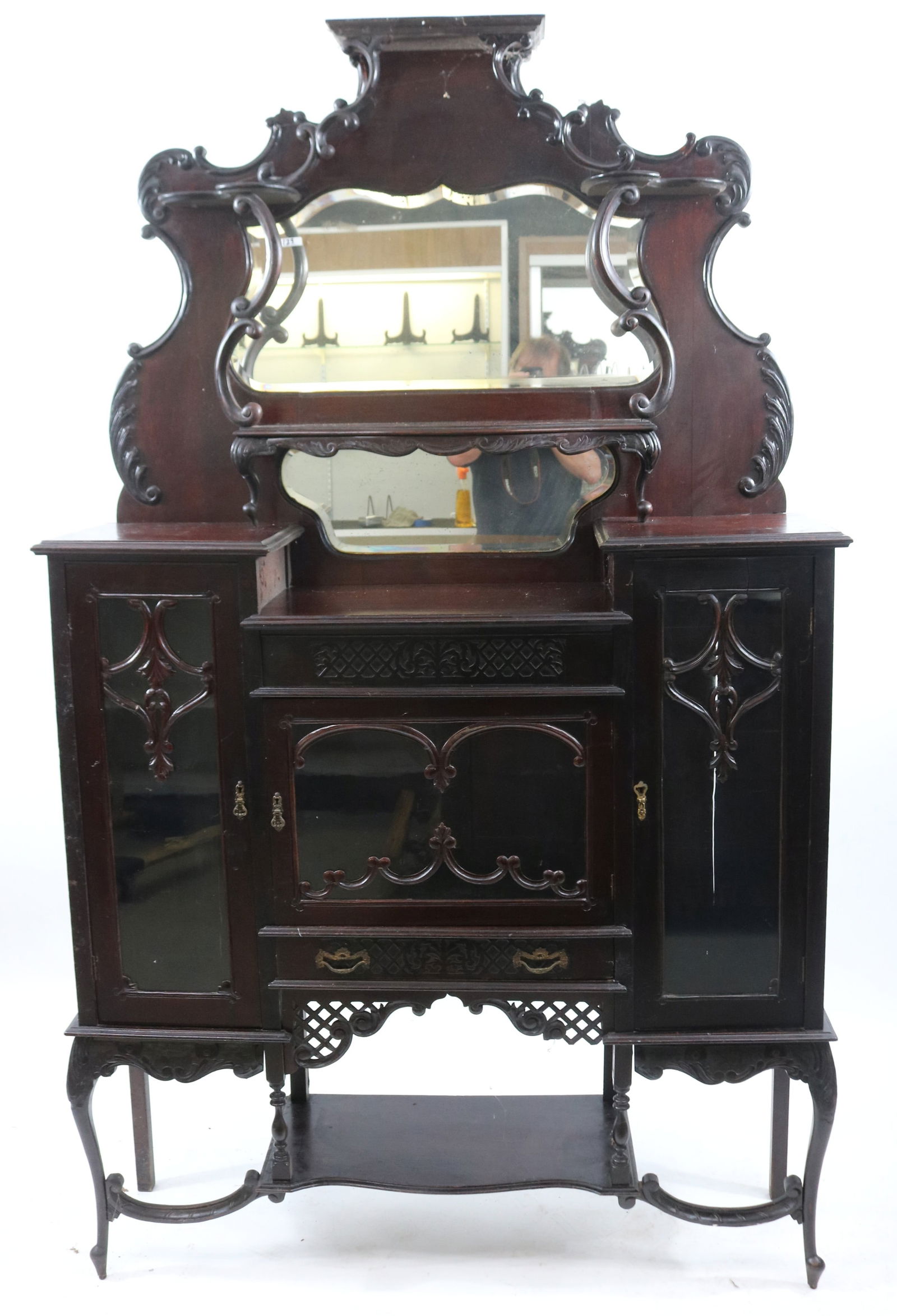 ORNATE EBONIZED MAHOGANY ETAGERE, SHAPED MIRROR: BACK, 3 GLASS DOORS, ORNATE CARVINGS, 80 3/4" H, 49" W, 14 1/4" D, SOME MISSING TRIM