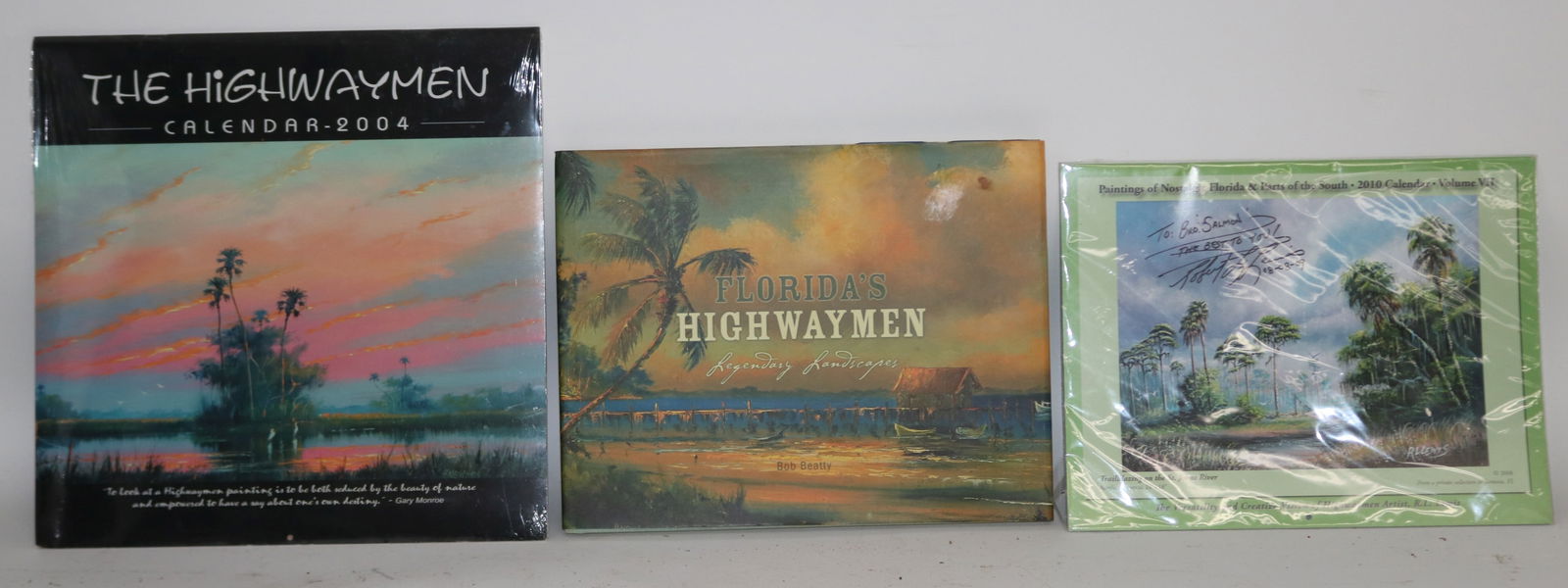 LOT HIGHWAYMEN MEMORABILIA, BOOK BY BOB BETTY: WITH DUST JACKET, 2004 CALENDAR IN ORIGINAL PLASTIC SEAL & ROBERT L. LEWIS SIGNED 2010 CALENDAR