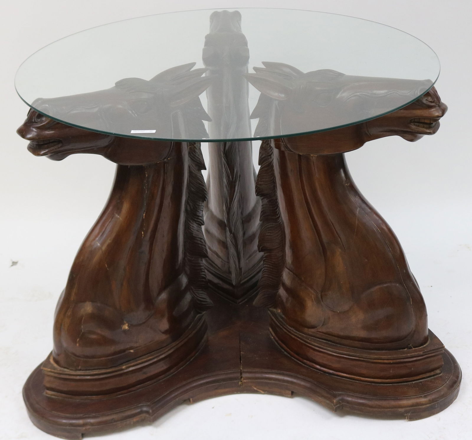 CONTEMPORARY CARVED MAHOGANY GLASS TOP TABLE, 3: HORSE HEAD SUPPORTS, 1 HEAD LOOSE, BASE SHOWS CRACKING, ORIGINAL FINISH, 29 3/4" H, 42" DIA. AT BASE, 36 1/2" DIA. TOP