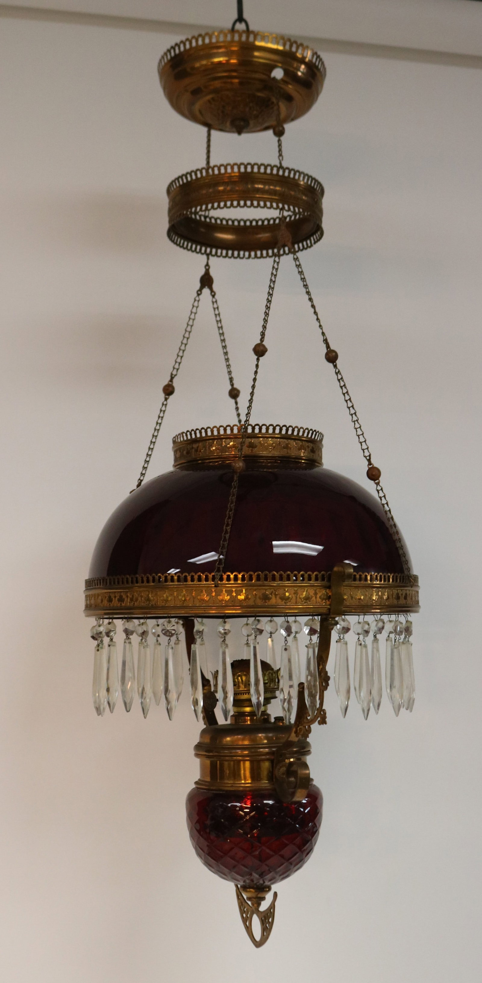 VICTORIAN BRASS & RUBY GLASS HANGING LAMP GLASS: WITH QUILTED DESIGN, MISSING PULL DOWN MECHANISM, NO CRACKS OR CHIPS, 38" H, 13" DIA., CUT PRISMS