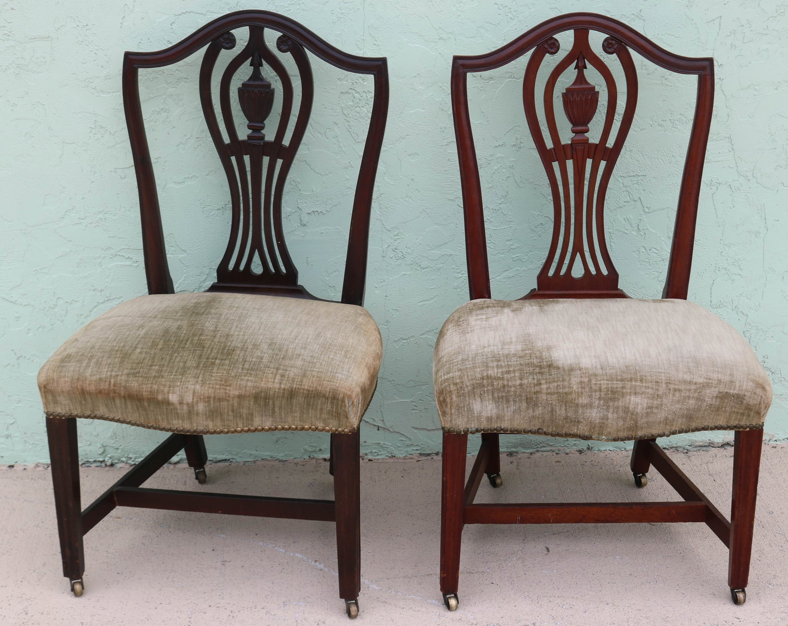 PAIR 19TH C. HEPPLEWHITE SIDE CHAIRS, MAHOGANY,: SHIELD SHAPED BACKS WITH CARVED URNS, REUPHOLSTERED SHAPED SEATS, REEDED FRONT LEGS, OLD FINISH, 37 1/2" H, 22 1/4" W, 18 1/2" D, 18" SEAT HEIGHT, ON CASTERS