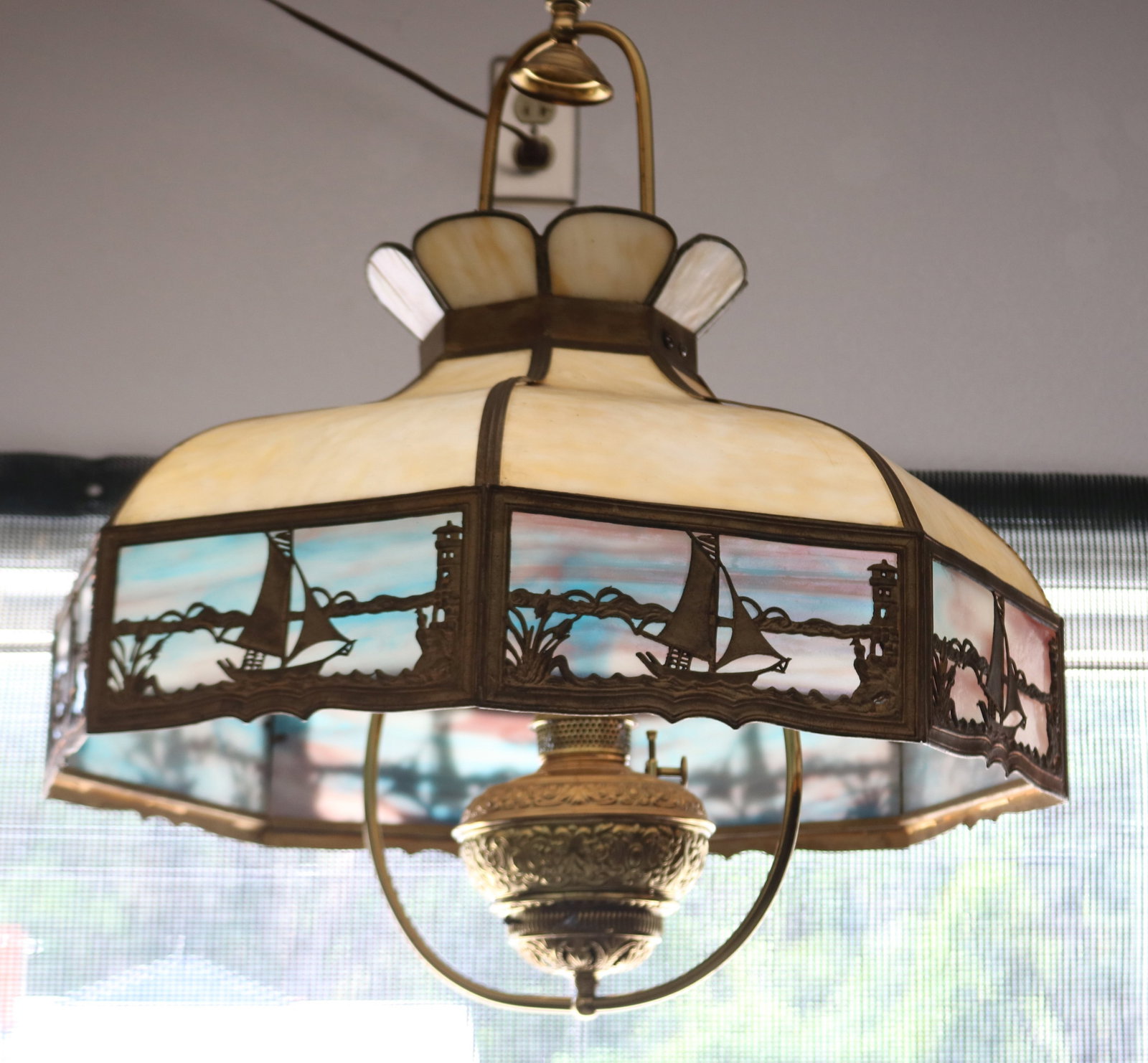 UNUSUAL SLAG GLASS HANGING LAMP WITH KEROSENE: BURNER, BENT CARMEL SLAG & BLUE PANELS, BRASS FRAME, SCENIC SAILBOAT DESIGN, 24" H, 23" DIA.