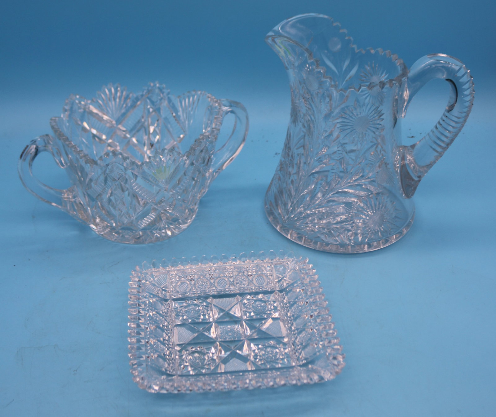3 PCS. CUT GLASS HANDLED PITCHER WITH FLORAL: DESIGN, 8 1/2" H, HANDLED TUB 5" H, SQUARE TRAY 6 3/4" X 6 3/4", TRAY SHOWS MINOR ROUGHAGE