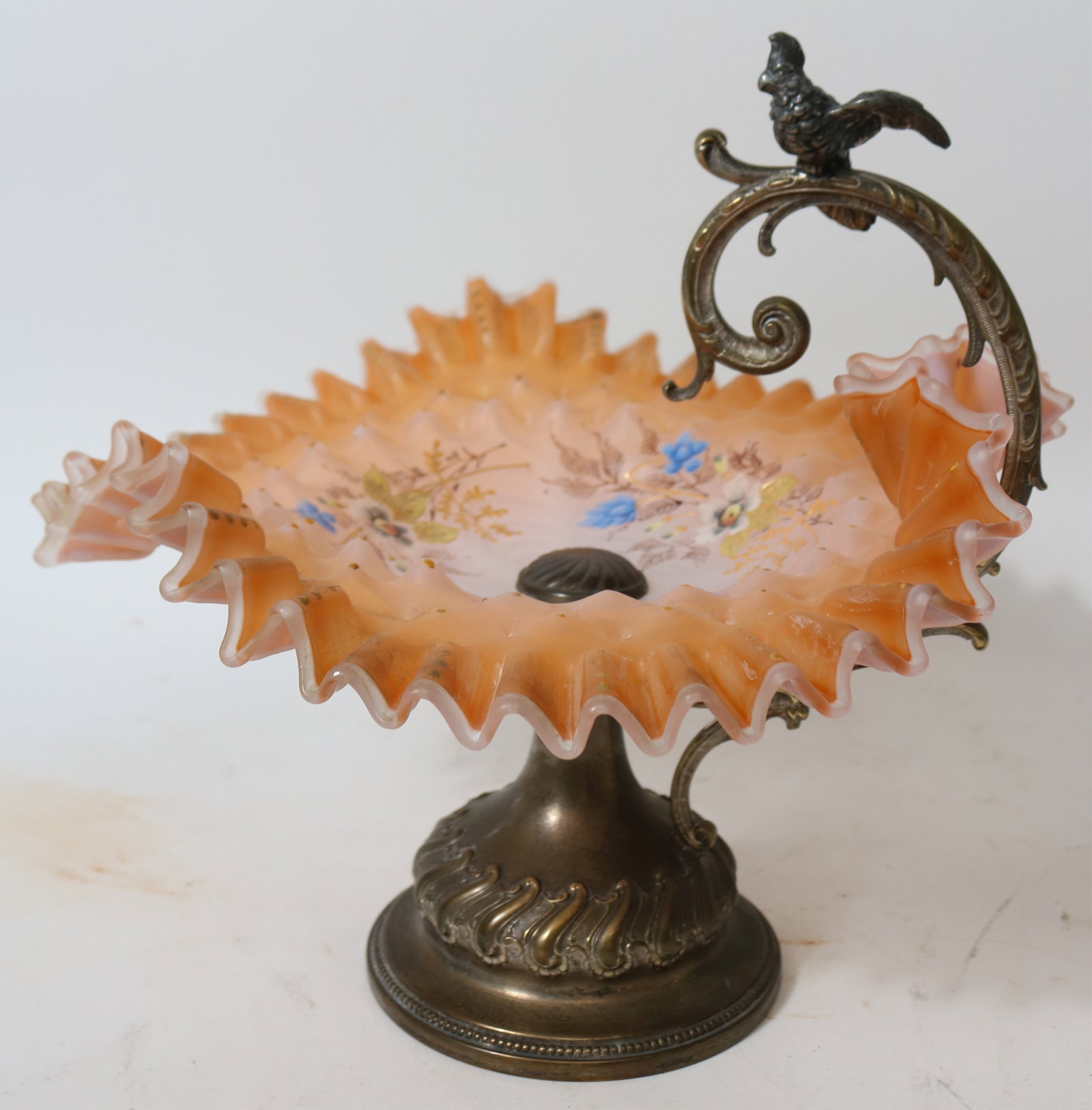 VICTORIAN BRIDES BOWL, ORANTE SILVER PLATED: HOLDER WITH COCKATIEL, APRICOT ENAMELED SATIN GLASS WITH RUFFLED EDGE, 10" H, 10 1/2" W, 11" D
