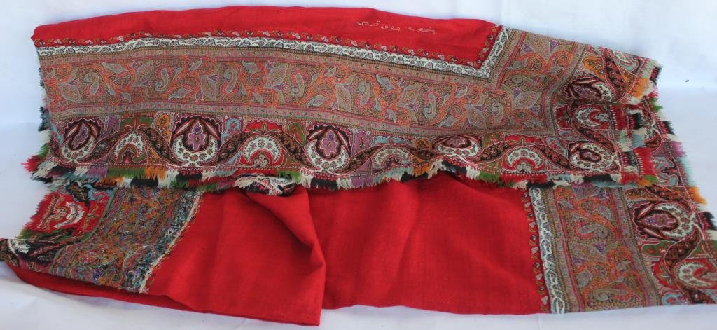 KASHMIR PAISLEY TABLE COVER WITH: RED FIELD, SHOWS MOTH DAMAGE, AND SOME SEPARATIONS IN PAISLEY, 5' 2" X 5' 2", SIGNED