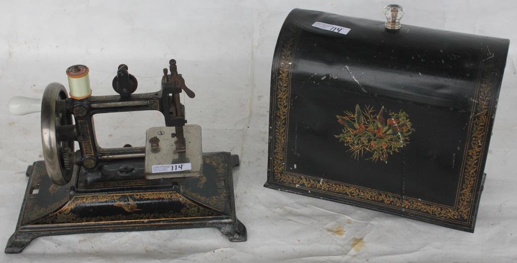 UNUSUAL MINIATURE TRAVELING SEWING MACHINE: MADE IN GERMANY WITH ORIGINAL STENCIL AND COVER. APPRX 10"H X 11"W X 6 1/4"D, GOOD OVERALL CONDITION, SOME SLIGHT SCRATCHING TO COVER
