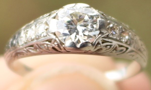 14K WHITE GOLD RING WITH BRILLIANT .78CT DIAMOND: MINE CUT, BEZEL SET AND 2-5 POINT DIAMONDS ON EITHER SIDE OF SOLITAIRE. 3.2G, SZ 6.6