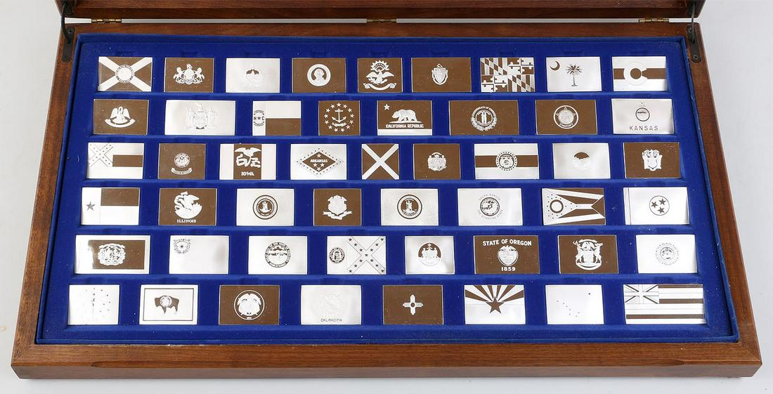 Set of (51) sterling state flag plaques: Set of (51) sterling state flag plaques, including an extra Virginia, case and informational booklet. All marked. Minor scratches to one, and one Virginia slightly corroded. Largest 1-1/2''h, 3''w. To
