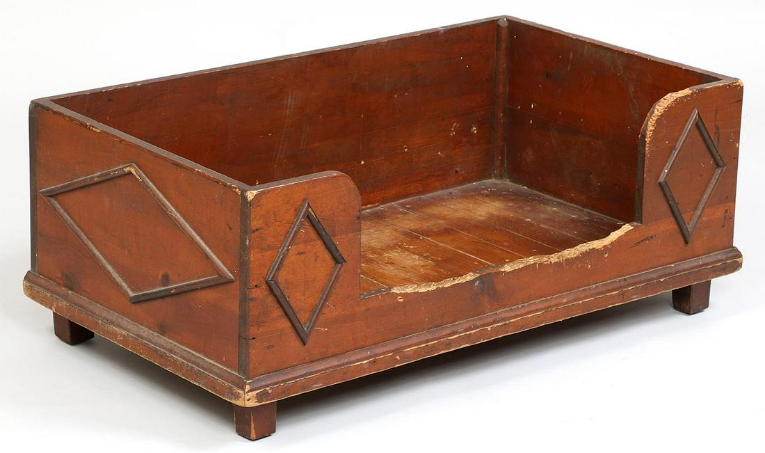 19th/20th century dog bed: 19th/20th century dog bed with applied diamond molded decoration, in red stain. Wear and chew marks. Provenance: purchased by present owner from a Greenport, Long Island family. 13-3/4''h, 35''w, 20-1