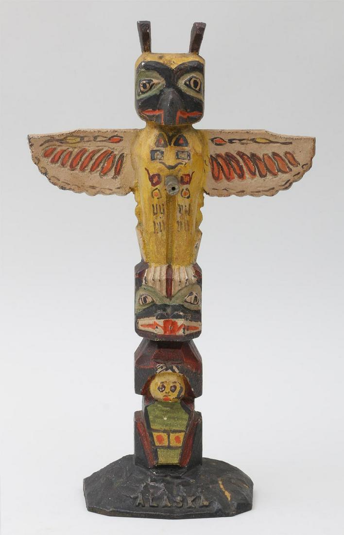 Cast iron painted totem pole door stop: Cast iron painted totem pole door stop with ''Alaska'' relief on base. Wear from use. 12-1/4''h, 7-1/4''w.
