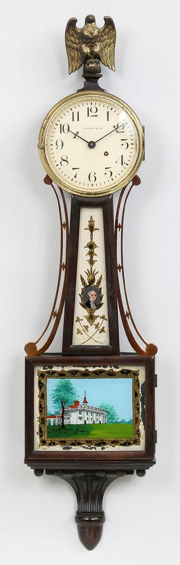Tiffany & Co. banjo clock: Tiffany & Co. banjo clock with eagle finial, reverse painted portrait on glass panel of George Washington to neck, and reverse painted image of house on glass panel to base. Chips to paint, wear to gi