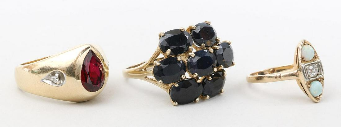 Group of (3) gold rings: Group of (3) gold rings, to include: 14k pear cut ruby with diamonds; 14k child's ring with center .15ct round cut diamond flanked by (2) opals, (inclusion to diamond); and 10k sapphire cocktail ring.