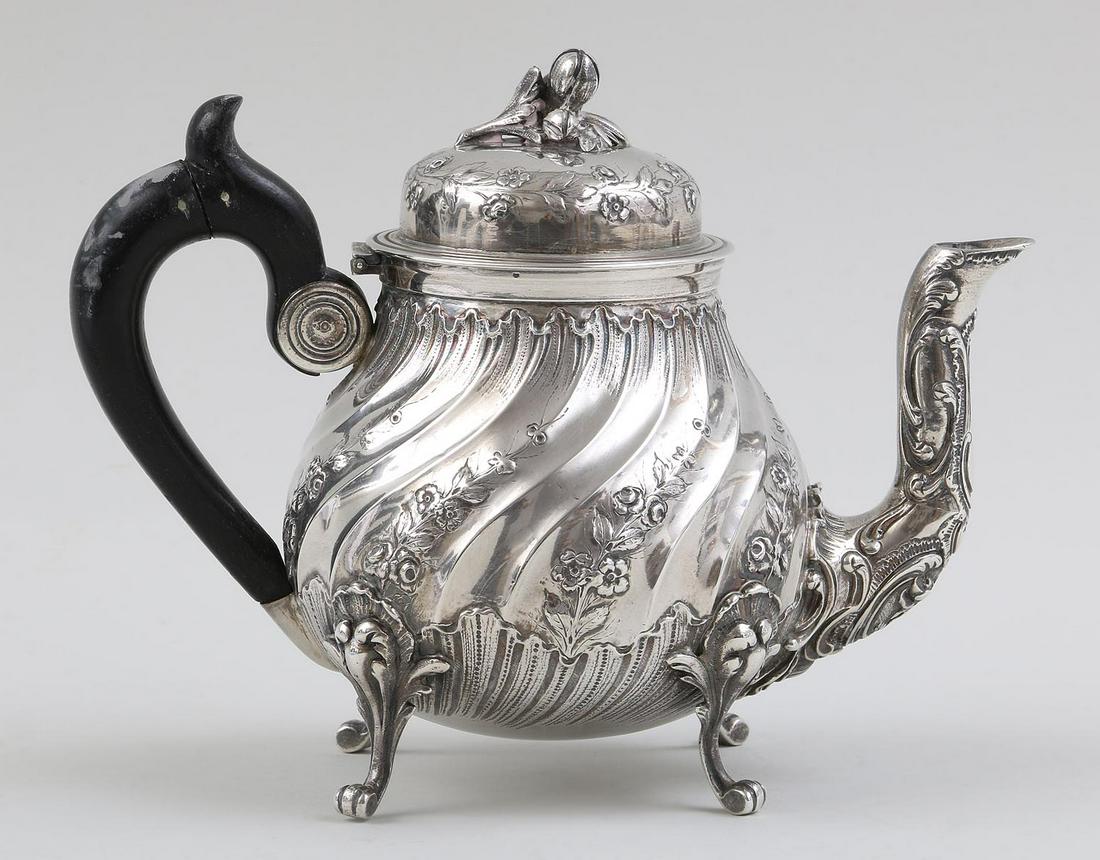 French silver teapot: French silver teapot with floral knop and decoration, wood handle, on four feet, marked for Emile Delaire, 19th/20th century. Repair to handle. 6''h. Total approximate weight 15.9 troy oz.