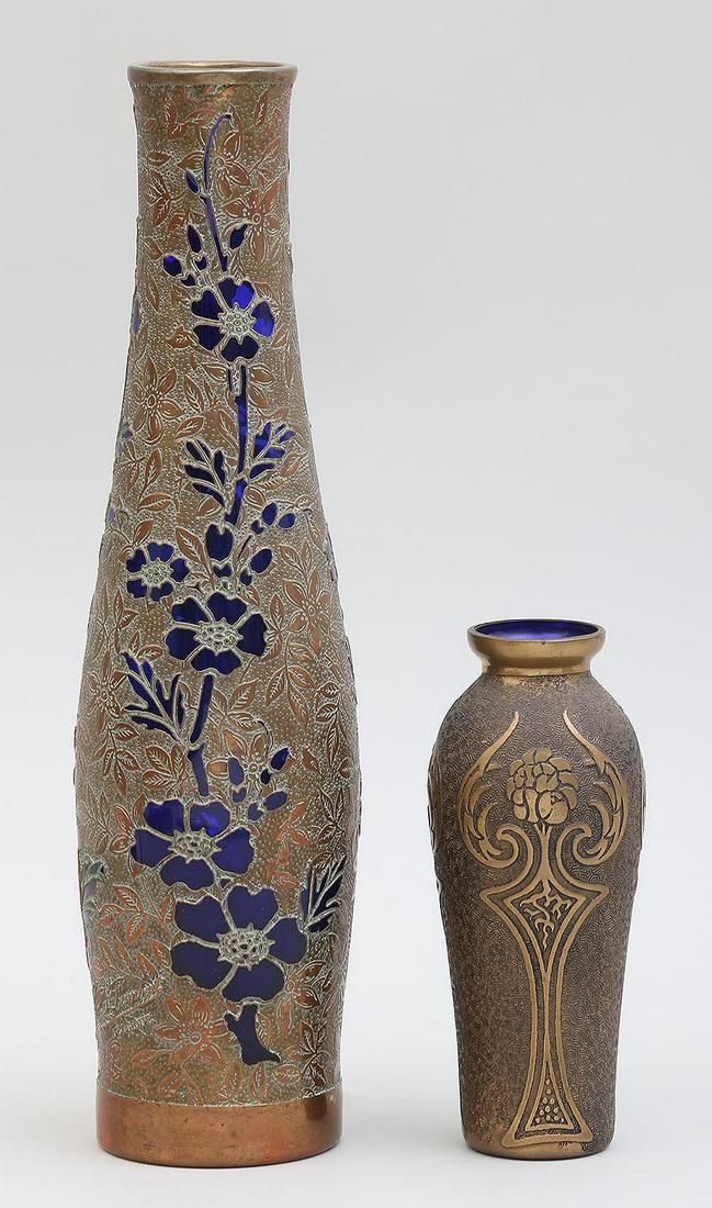 Group of (2) Val St. Lambert gilt vases: Group of (2) Val St. Lambert gilt vases, to include: small with blue glass lining; and floral decorated with blue glass flowers. Both marked. Crack in glass and minor dent to rim of floral vase. Talle