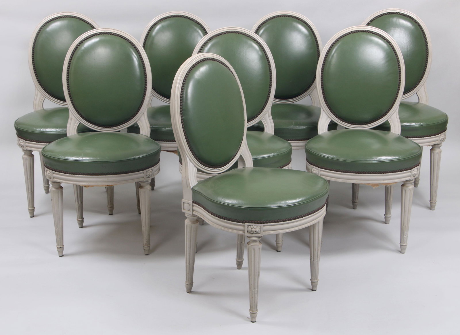Set of (8) Louis XVI style balloon back dining chairs: Set of (8) Louis XVI style balloon back dining chairs, upholstered in olive green faux leather, painted grey. Some splitting to upholstery surface, leg with dog chew marks. 36-1/4''h.