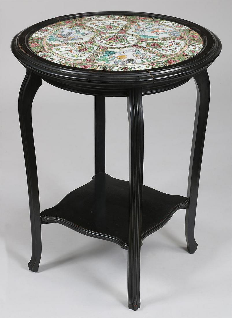 Rose Medallion center table: Rose Medallion center table having a large round porcelain top set in a black lacquered table with bottom shelf. Wear to porcelain decoration, shrinkage split to wood frame. 29-3/4''h, 23-3/4''dia.