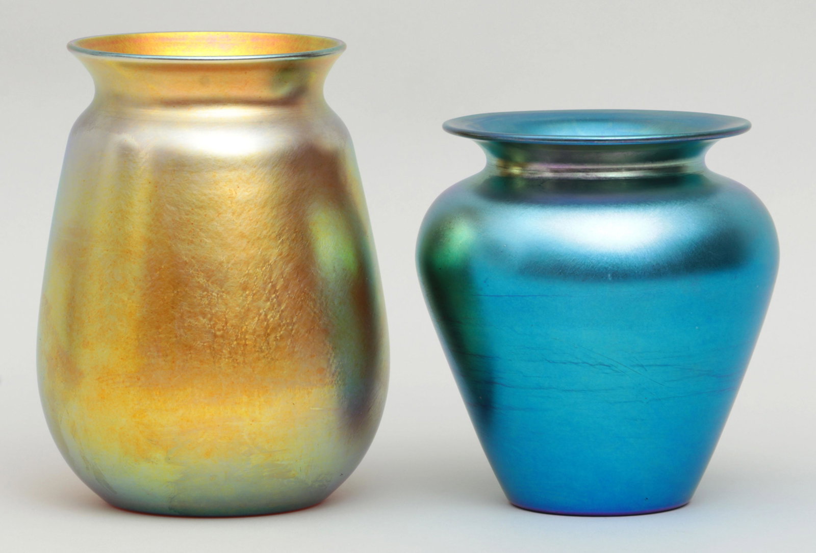 Steuben and Durand iridescent art glass vases: Group of (2) iridescent art glass vases, to include: yellow Steuben; and blue Durand. Both signed. Minor scratches to both, scuff mark to Steuben. Larger 8''h.